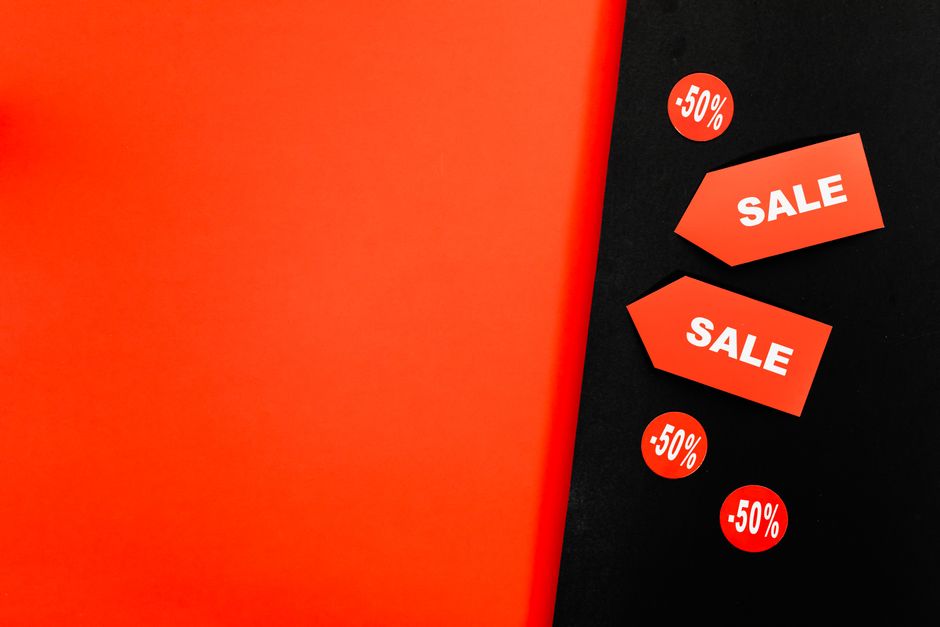 Fundo dinâmico vermelho e preto com etiquetas de venda e placas de 50% de desconto para promoções.